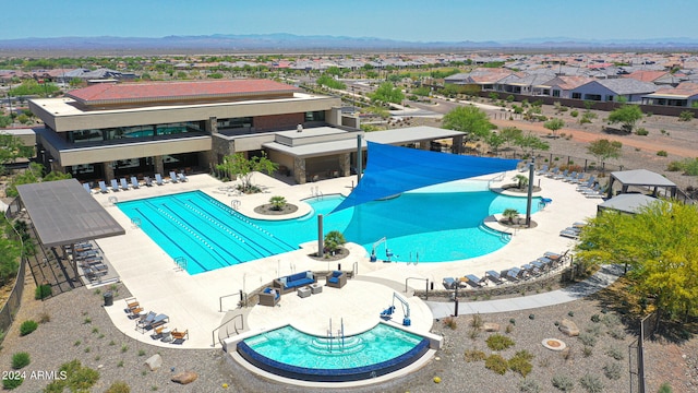 view of swimming pool featuring a hot tub and a patio area