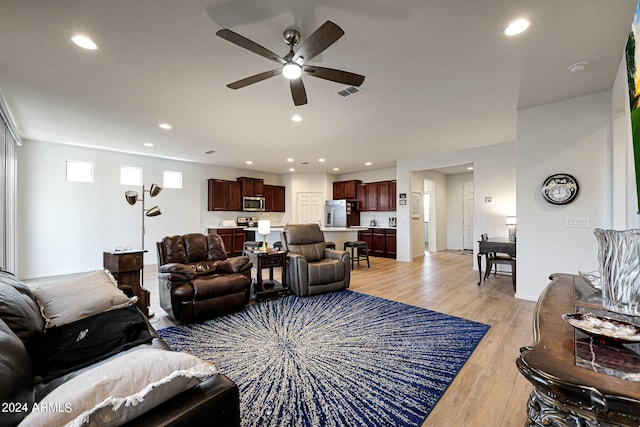 living room with ceiling fan and light wood-type flooring