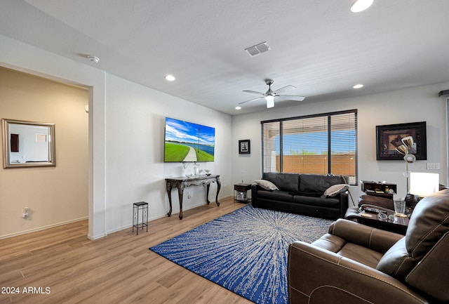 living room with ceiling fan and light hardwood / wood-style flooring