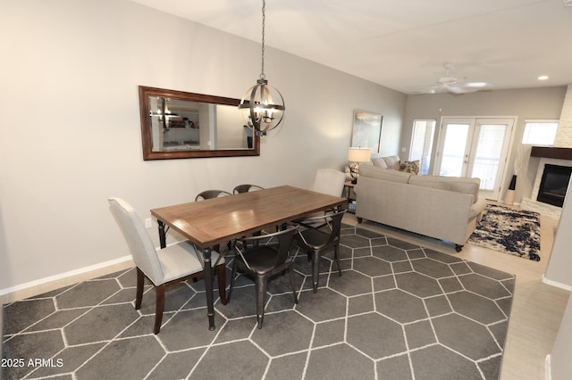 7021 E Earll Dr Unit 204, Scottsdale, AZ 85251 - dining room with a chandelier, a ceiling fan, a glass covered fireplace, baseboards, and recessed lighting