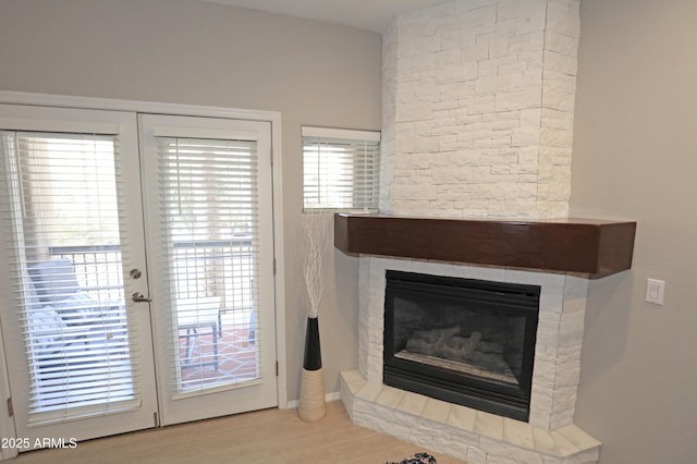 7021 E Earll Dr Unit 204, Scottsdale, AZ 85251 - detailed view of a stone fireplace, wood finished floors, and french doors