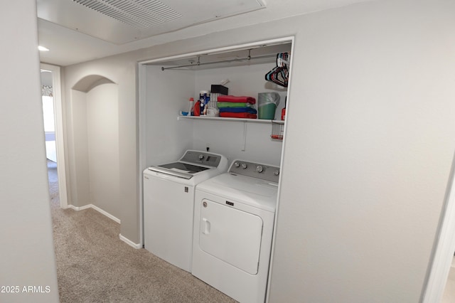 7021 E Earll Dr Unit 204, Scottsdale, AZ 85251 - laundry room with separate washer and dryer, light colored carpet, baseboards, and arched walkways