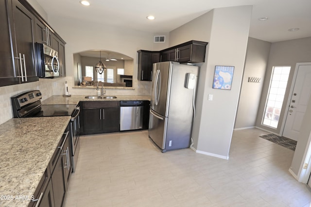 7021 E Earll Dr Unit 204, Scottsdale, AZ 85251 - kitchen featuring stainless steel appliances, a sink, backsplash, arched walkways, and recessed lighting