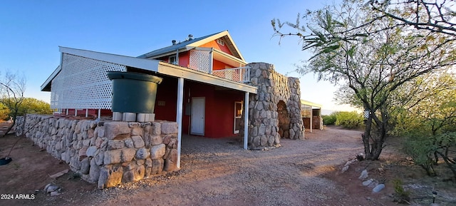 property exterior at dusk with a balcony