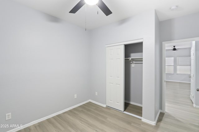 unfurnished bedroom featuring light wood finished floors, baseboards, a closet, and a ceiling fan