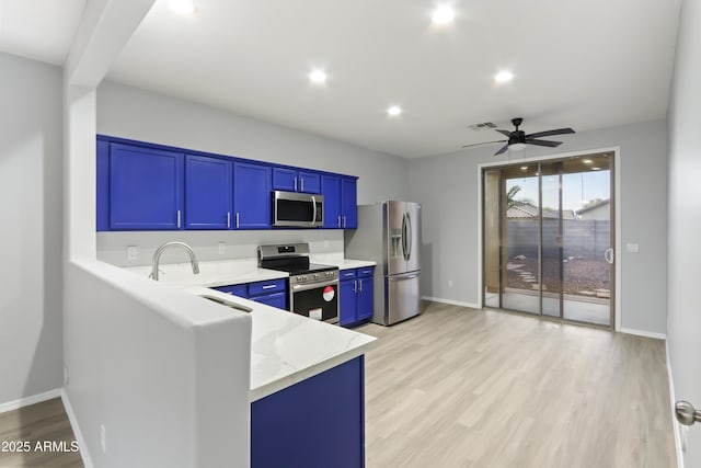 kitchen featuring stainless steel appliances, light wood-style floors, ceiling fan, and light stone counters