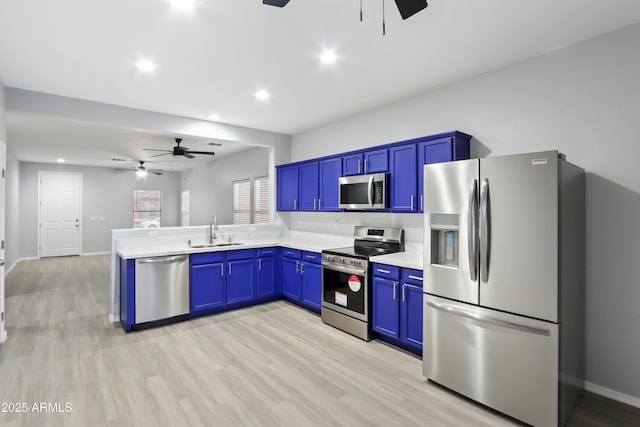 kitchen with light countertops, a sink, stainless steel appliances, and ceiling fan
