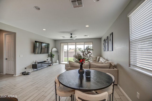 dining space with ceiling fan and light hardwood / wood-style flooring