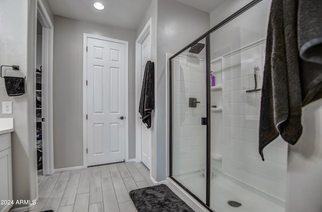 bathroom featuring walk in shower, hardwood / wood-style floors, and vanity