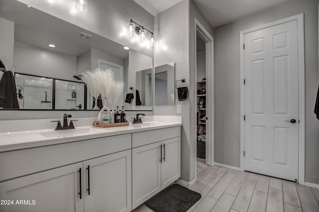 bathroom with vanity with extensive cabinet space, double sink, and hardwood / wood-style floors