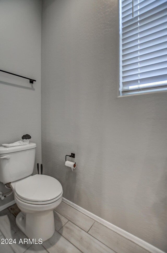 bathroom featuring tile flooring and toilet