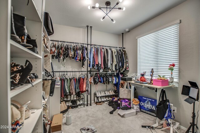 spacious closet with carpet and an inviting chandelier