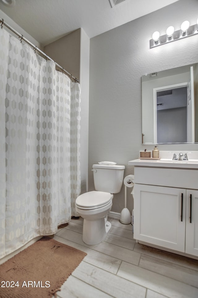 bathroom with oversized vanity, toilet, and tile floors