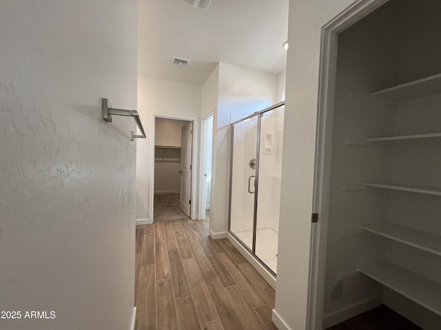 hallway featuring baseboards, visible vents, and wood tiled floor