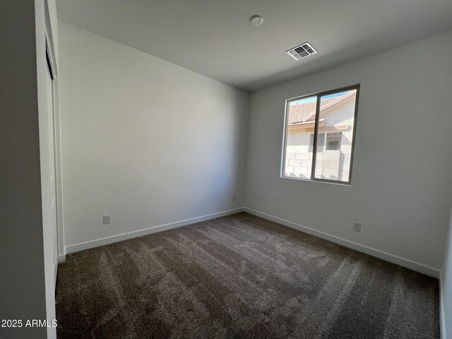 carpeted empty room featuring baseboards and visible vents