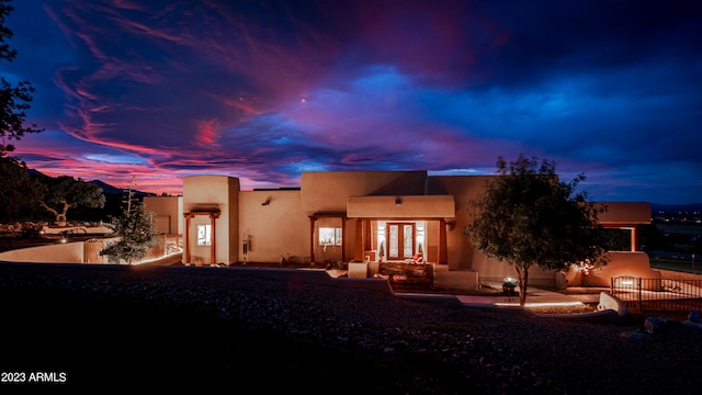 back house at dusk with a patio