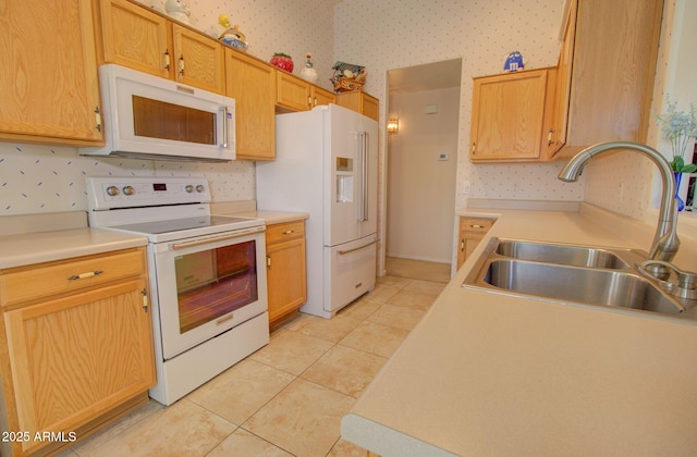 kitchen with sink, white appliances, light tile patterned floors, and light brown cabinets