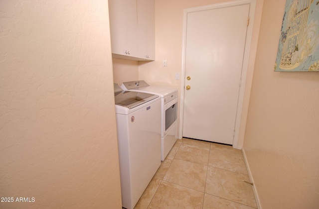 laundry room with cabinets, separate washer and dryer, and light tile patterned floors