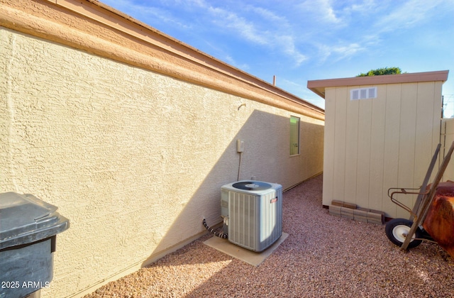 view of home's exterior with central AC and a shed