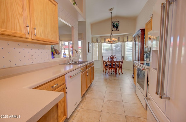 kitchen featuring pendant lighting, light brown cabinetry, sink, light tile patterned floors, and white appliances