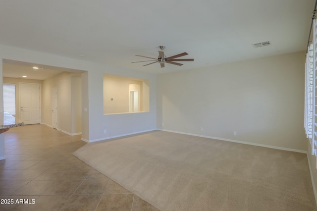 tiled spare room featuring ceiling fan