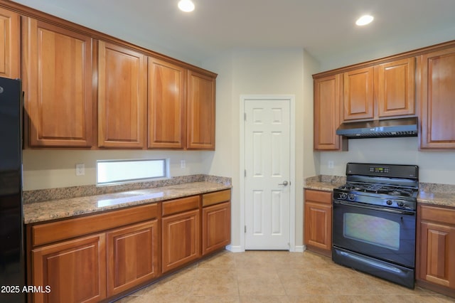 kitchen with light stone counters, light tile patterned flooring, and black appliances