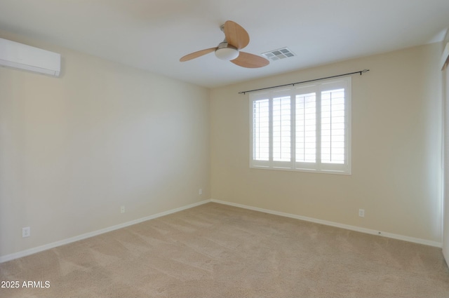 spare room featuring light carpet, a wall mounted AC, and ceiling fan