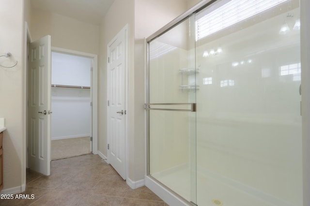 bathroom featuring tile patterned flooring, vanity, and a shower with shower door