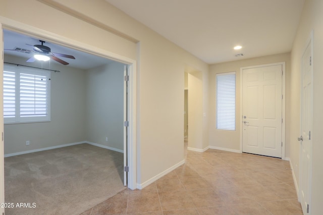 carpeted foyer entrance with ceiling fan