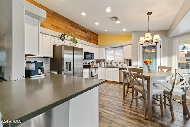 kitchen featuring stainless steel appliances, dark countertops, lofted ceiling, visible vents, and decorative backsplash