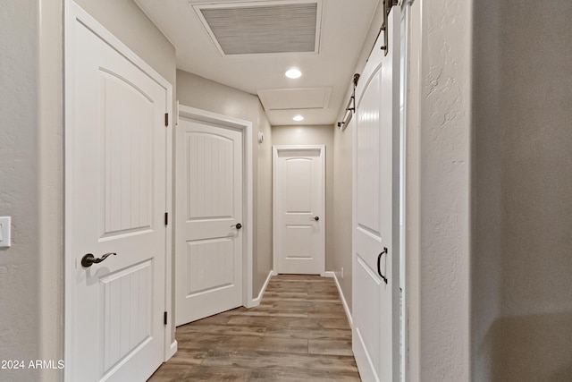 hallway with recessed lighting, visible vents, attic access, wood finished floors, and baseboards