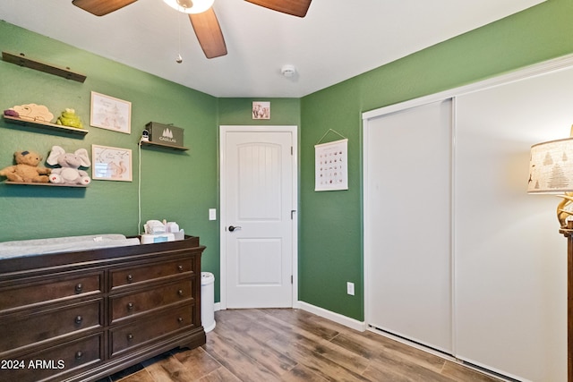 bedroom featuring a closet, ceiling fan, baseboards, and wood finished floors