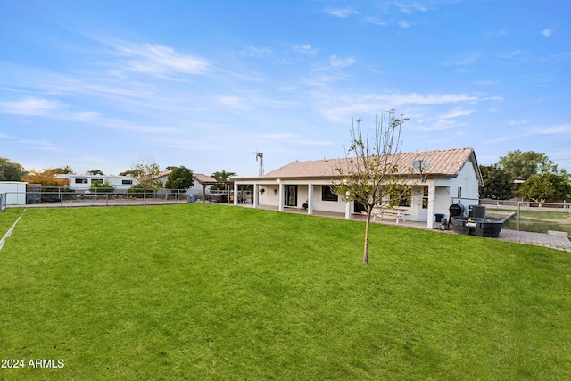 back of property featuring a patio area, a fenced backyard, and a lawn