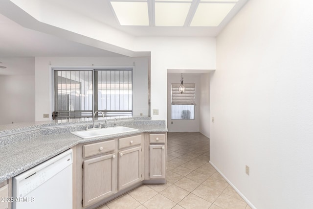 kitchen with light brown cabinetry, sink, hanging light fixtures, light tile patterned floors, and dishwasher