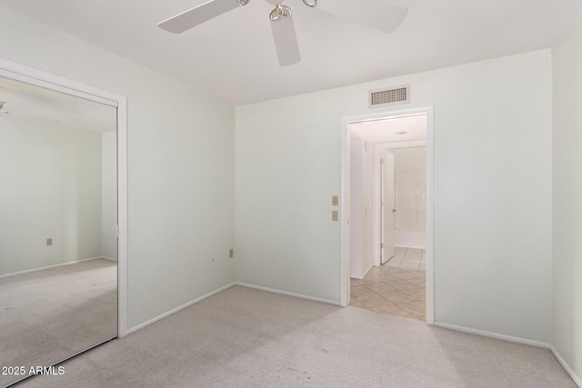 spare room with light colored carpet and ceiling fan