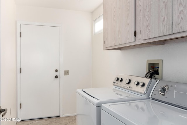 laundry area featuring cabinets, light tile patterned floors, and independent washer and dryer