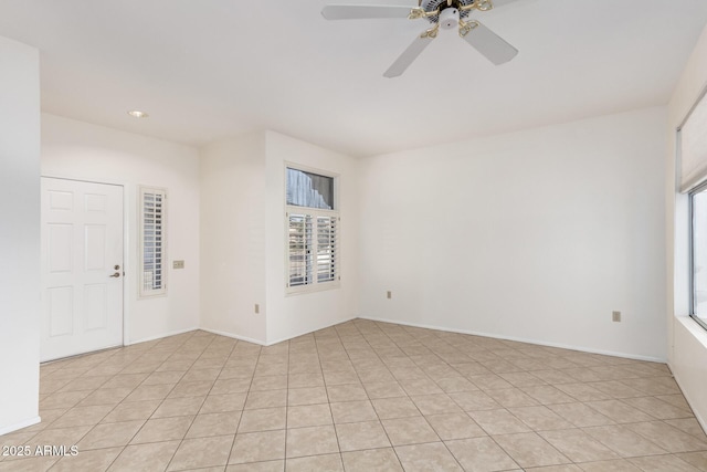 tiled empty room featuring plenty of natural light and ceiling fan