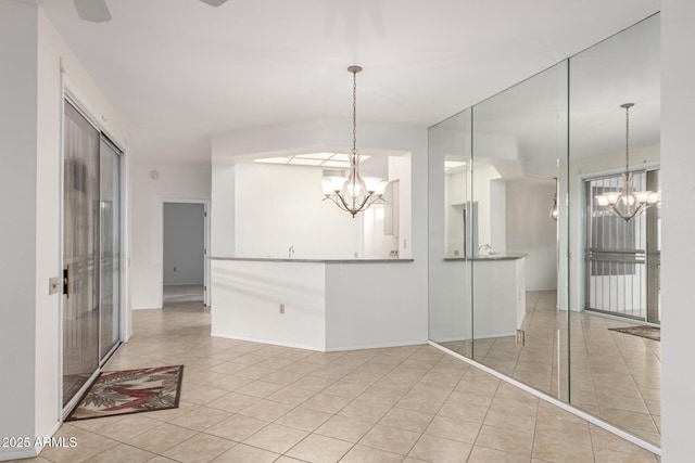 spare room with light tile patterned floors and a chandelier