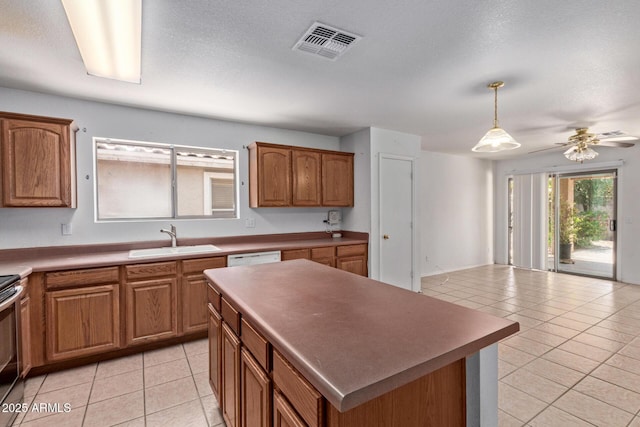 2421 W Romley Rd, Phoenix, AZ 85041 - kitchen featuring a sink, light tile patterned floors, brown cabinetry, and a center island