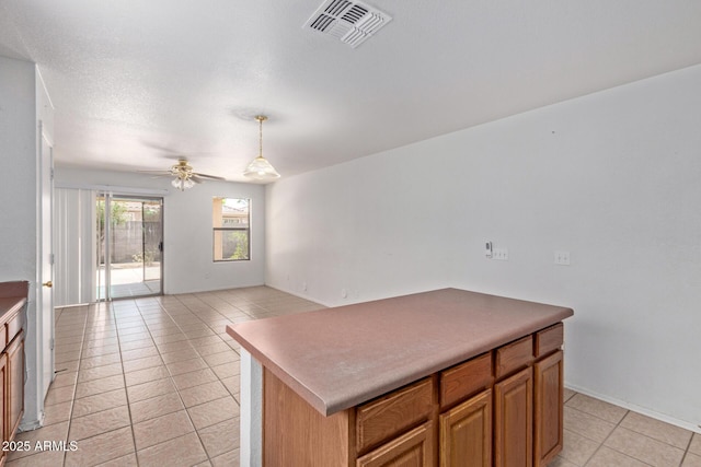 2421 W Romley Rd, Phoenix, AZ 85041 - kitchen featuring light tile patterned floors, a ceiling fan, a center island, open floor plan, and decorative light fixtures