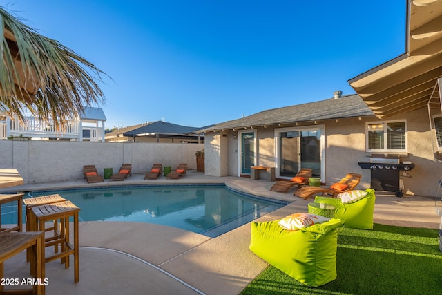 view of swimming pool featuring grilling area, a patio, a fenced in pool, and fence