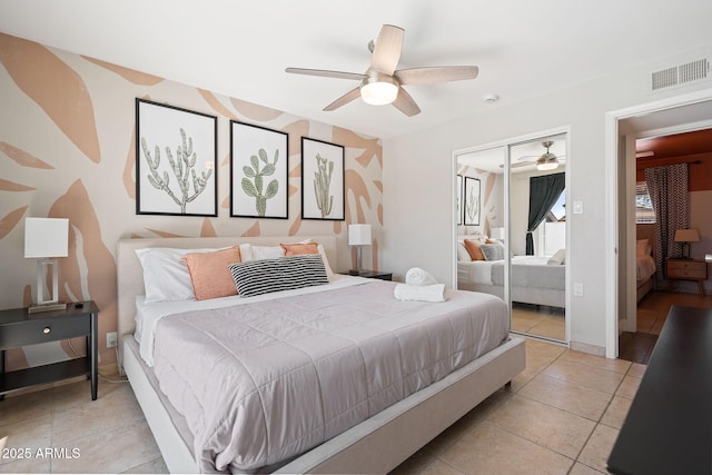 bedroom featuring visible vents, ceiling fan, baseboards, light tile patterned floors, and a closet