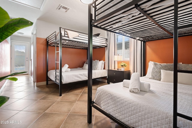 tiled bedroom featuring visible vents and multiple windows