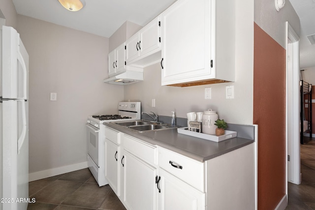 kitchen with white appliances, baseboards, dark tile patterned flooring, a sink, and white cabinetry