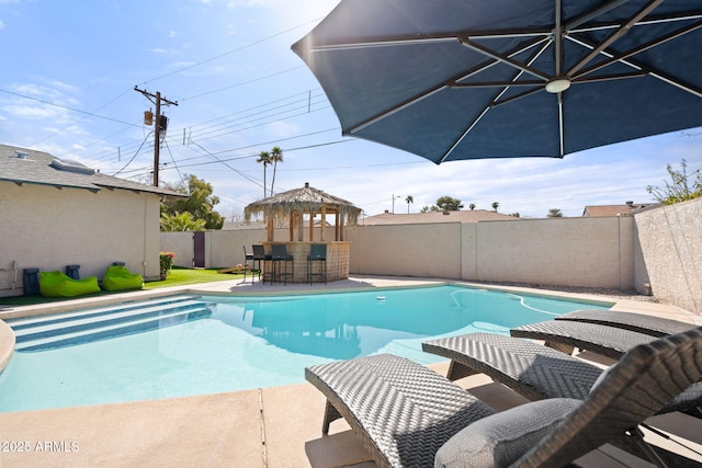 view of swimming pool with a fenced in pool, a patio, a fenced backyard, and outdoor dry bar