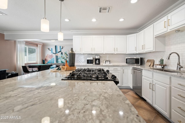 kitchen with visible vents, a sink, ornamental molding, tile patterned flooring, and stainless steel appliances