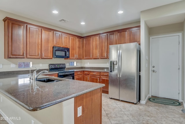 kitchen with sink, light tile patterned floors, dark stone countertops, kitchen peninsula, and black appliances