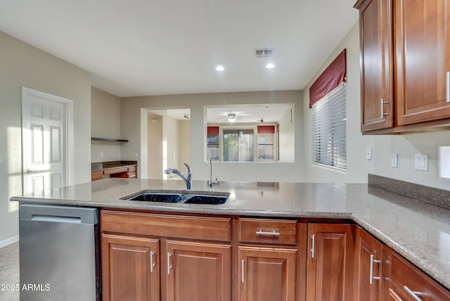 kitchen with kitchen peninsula, dishwasher, sink, and light stone countertops