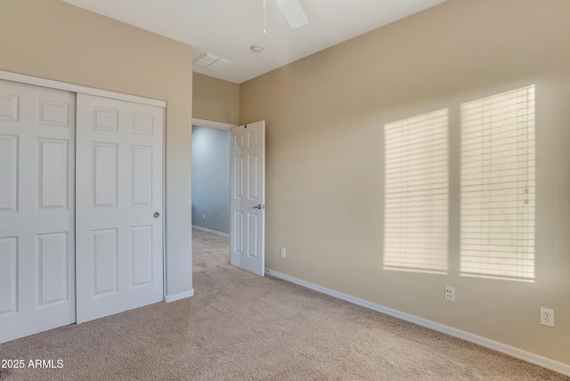 unfurnished bedroom with light colored carpet, ceiling fan, and a closet