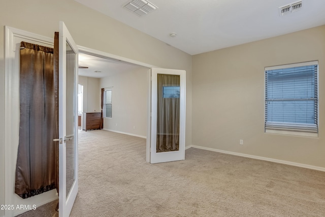 unfurnished room featuring light carpet